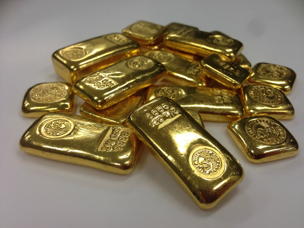 Stacked gold bars on a dark surface